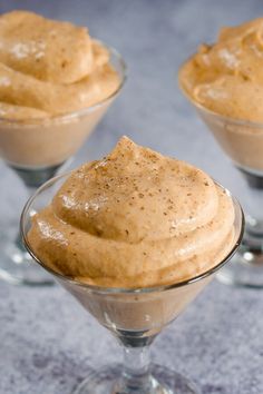 three desserts in small glass dishes on a table