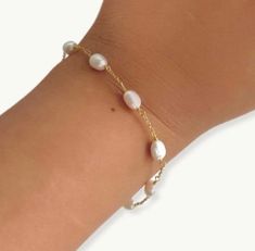 This dainty gold plated bracelet features alternating oval pearls, making it a timeless piece that will never go out of style. Whether you're looking for a subtle addition to your everyday look or a statement piece for a special occasion, the pearl chain bracelet is the perfect choice. It is dainty and elegant also perfect for wedding day or for bridesmaids gift.   PRODUCT DETAILS  Size: 6.2 inch length + 1 inch extension  Material : freshwater pearls and 18k double gold plated 925 silver chain. packaged in ILLÁRI jewelry box  free cleaning cloth included  visit our website www.shopillari.com  POLICY  30 day return policy for unworn and not damaged . shipping is paid by you for all returns. Dainty Pearl Bracelets With Tiny Beads, Dainty Pearl Chain Bracelet, Dainty Gold-plated Bracelets With Pearl Charm, Dainty Gold Plated Bracelets With Pearl Charm, Dainty Chain Bracelet With Pearl Charm, Handmade Delicate Pearl Bracelet, Adjustable Pearl Bracelet With Delicate Chain, Adjustable Minimalist Pearl Chain Bracelet, Adjustable Delicate Chain Pearl Bracelet