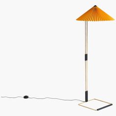 a lamp that is on top of a white surface next to a black and gold base