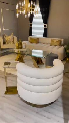 a living room filled with white furniture and gold accents