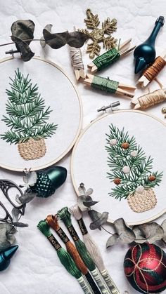 two cross stitch hoops with christmas ornaments and other items on them, all in different designs