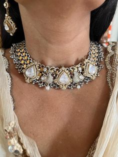 This exquisite choker necklace set is meticulously handcrafted by fine jewelry artisans, featuring intricate Kundan Polki work in 925 silver. Perfect for destination weddings, this set includes statement earrings that complement the choker beautifully, ensuring you stand out on your special day. Necklace Weight: 138 grams Materials: 925 Silver, Kundan Polki Closure Type: Premium Adjustable Dori The matching statement earrings are designed to make a bold impression. Earrings Weight: 18 grams per pair. Earrings Dimensions: Length is 6.5 cm and width is 2.5 cm. Closure Type: Push Back Closure This luxurious set combines timeless elegance with exceptional craftsmanship, making it an ideal choice for any grand occasion. Elegant Festive Choker With Intricate Design, Elegant Silver Kundan Necklace Hand Set, Silver Temple Jewelry Necklace For Reception, Silver Temple Necklace For Reception, Luxury Hand Set Kundan Necklace, Ornate Jewelry For Festivals And Receptions, Ornate Jewelry For Reception And Festivals, Silver Kundan Necklace With Elegant Design For Festivals, Silver Kundan Necklace With Intricate Design For Reception