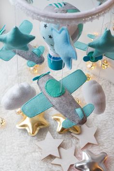 a baby mobile with stars and airplanes hanging from it