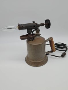 an old fashioned coffee grinder with a light on it's side and a cord attached to the handle