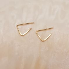 Nice little 14k gold filled earrings in the shape of a triangle.  The earrings are made of 14k gold filled wire and are hammered to keep them solid.  The total length of the earrings is 1 cm and they are sold per pair.  The earrings come with a rubber stopper, so that they stay in place.  Each earring is unique and handmade in our own studio. As a result, they may differ slightly from the photo.  Also available in a medium version. Gold Triangle, Daisy Earrings, Earrings Hoop, Gold Filled Earrings, Handmade Gold, Small Earrings, Jewelry Earrings Hoops, Earrings Gold, Netherlands