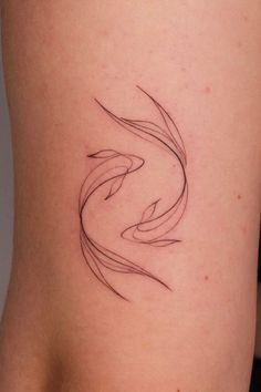 a woman's thigh with a tattoo design on the back of her leg, which is shaped like a fish