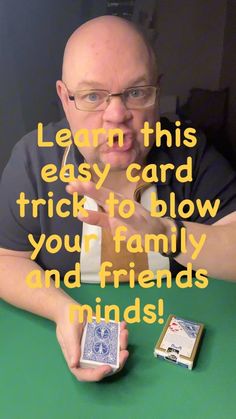 a man sitting at a table with two cards in front of him and the caption reads learn this easy card trick to blow your family and friends minds