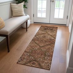 a door way with a bench and rug on the floor in front of it,