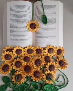 an open book with crocheted sunflowers on it