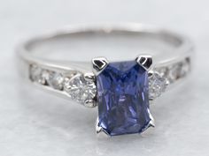 a ring with a blue stone surrounded by diamonds