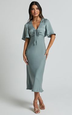 Get ready to turn heads in the Nicholla Midi Dress! This stunning A-line dress features a ruched front and angel sleeves that add an ethereal touch. Made from luxurious satin polyester, this dress has a V-neckline and falls perfectly at midi length for a flattering silhouette. Whether you're attending a cocktail party or a wedding as a guest, the sage green color of this dress will make you stand out from the crowd. With its short sleeves and comfortable fit, the Nicholla Midi Dress is both styl Summer Satin Dress With Gathered Sleeves, Satin V-neck Dress With Gathered Sleeves, Spring Satin Midi Dress With Gathered Sleeves, Satin V-neck Midi Dress With Draped Sleeves, Satin Ruched V-neck Midi Dress, Spring Satin Dress With Flutter Sleeves, V-neck Satin Dresses With Gathered Sleeves, Elegant Dress With Gathered Neckline And Flutter Sleeves, Elegant Ruched Satin Dress For Brunch