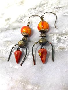 Rustic tribal looking earrings with beautiful lampwork beads by another Etsy artisan. Interesting pair with good movement and sharp orange and yellow colors. Wires are by Vintaj and are lead and nickel free. Artsy Orange Drop Earrings, Artisan Czech Glass Beaded Round Earrings, Artisan Czech Glass Round Bead Earrings, Nickel-free Beaded Drop Earrings, Unique Czech Glass Earrings With Ear Wire, Bohemian Orange Czech Glass Earrings, Unique Teardrop Beaded Earrings, Unique Orange Earrings For Festival, Unique Orange Earrings With Dangling Beads