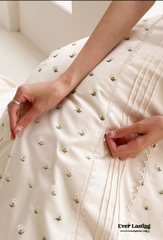 a woman in a white dress is holding her hand on the back of someone's skirt