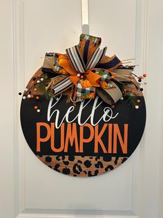 a hello pumpkin door hanger on the front door