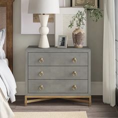 a bedroom with a bed, nightstand and pictures on the wall