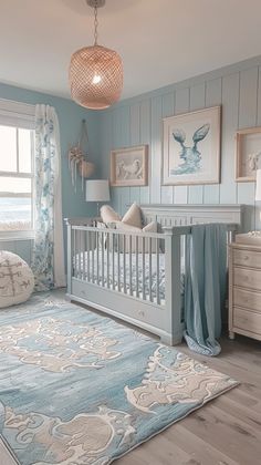 a baby's room with blue and white decor, including a crib bed