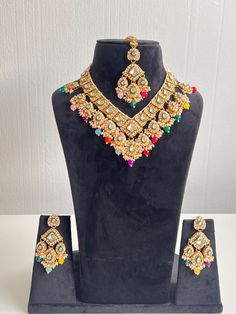 Showcasing exquisite craftsmanship, this stunning jewellery set is a true masterpiece, perfect for adding a touch of glamour to any outfit. Made by Harkirt trade, this Asian-inspired set is perfect for women who love bold statement pieces that make a statement. Crafted from high-quality materials in India, this beautiful semi-bridal Kundan set is a must-have for any jewellery collection. From the intricate detailing to the beautiful design, this jewellery set is sure to turn heads. Ideal for spe Elegant Multicolor Necklace For Festivals, Kundan Bridal Necklace With Matching Earrings, Elegant Multicolor Jewelry Sets For Weddings, Elegant Multicolor Necklaces For Festivals, Elegant Multicolor Hand Set Bridal Sets, Elegant Multicolor Bridal Sets With Stone Work, Elegant Multicolor Bridal Sets For Festive Occasions, Elegant Multicolor Wedding Sets, Elegant Multicolor Kundan Necklace For Celebrations