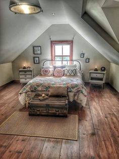 a bedroom with a bed, dresser and window in the atticed room that has wood flooring