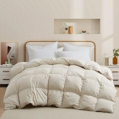 a bed with white comforters and pillows in a room