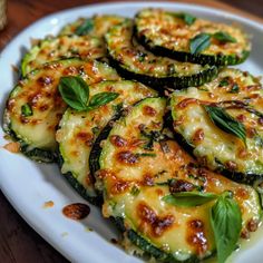 a white plate topped with zucchini covered in cheese