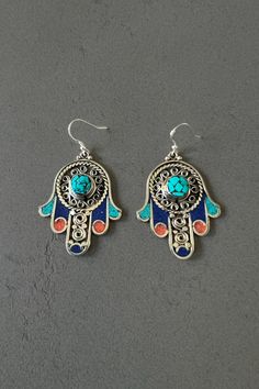 Hamsa hand earrings for woman hamsa hand pendant earrings gift for mom ethnic earrings for everyday earrings hand of Fatima earrings Buddha These ethnic copper alloy earrings feature a Hamsa hand design, embellished with colorful inlaid stones. The Hamsa hand is a symbol of protection and good luck in many cultures. Add a touch of cultural charm and good vibes to your look with these unique earrings. Item Details *Material: Copper Alloy *Earring size: 1.77in (4.5cm) x 1.34in (3.5cm) *Weight: 0.8 Buddha Earrings, Hamsa Hand Necklace, Hamsa Hand Earrings, Hamsa Hand Pendant, Hamsa Pendant, Alloy Earrings, Hand Of Fatima, Ethnic Earrings, Hamsa Hand