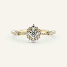 a yellow gold engagement ring with two diamonds on the band and a center diamond in the middle