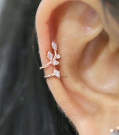 a close up of a person's ear with a flower shaped piercing on it