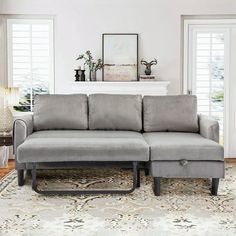 a gray couch sitting on top of a rug in a living room