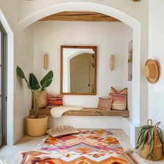 a room with a rug, mirror and potted plants on the floor in front of it