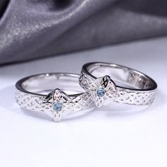 two silver rings with blue stones on them