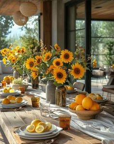 the table is set with sunflowers, lemons and oranges in vases