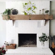 a living room with a white brick fireplace and potted plants on the mantel