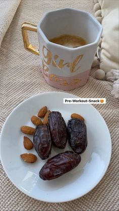 there are dates and almonds on the plate next to a cup of coffee,