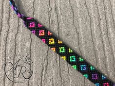 a multicolored bracelet is laying on the ground