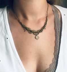 a close up of a woman wearing a white shirt and necklace with gold beads on it