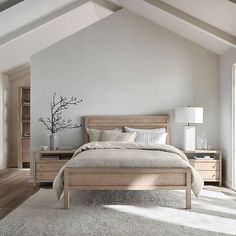 a bedroom with white walls and wooden furniture