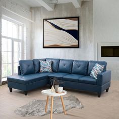 a living room with a blue sectional couch and coffee table in front of a fireplace