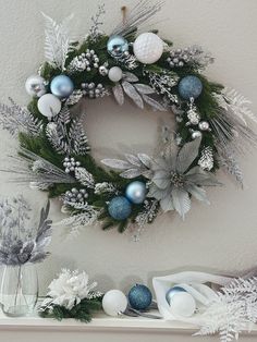 a christmas wreath is hanging on the wall next to other holiday decorations and vases