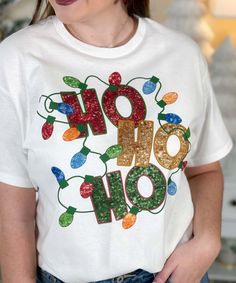 Elevate your festive style with our "Faux Sequin Ho Ho Ho Graphic Shirt." This cheerful shirt features a delightful graphic design of the words "Ho Ho Ho" adorned with a string of Christmas lights, all in faux sequins. Please note that these are graphic sequins, providing a sparkling appearance without the actual texture of real sequins.Our faux sequin design is not shiny/sparkly. This is a printed graphic design that is meant to give the look of sequins, it is not real sequins. It does look exactly like the photo as this is a printed graphic tee that shows the actual design printed on the tee.
Perfect for holiday gatherings, spreading cheer, or just adding a touch of merriment to your everyday look, the "Faux Sequin Ho Ho Ho Graphic Shirt" captures the festive spirit with a playful and co Christmas Shirts Vinyl, Homemade Shirts, Christmas Tee Shirts, Cute Christmas Shirts, Black Friday Christmas, Sequin Design, Holiday Sweatshirt, Ho Ho Ho, Christmas Tees