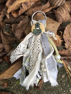 a stuffed animal is sitting on the ground next to some leaves and other autumn decorations