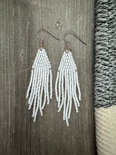 Earrings: Handmade beaded fringe earrings. Color and design: Matte white and tan colors in a feathery fringe shape.   Hooks: High quality hypoallergenic titanium commercial pure grade 1 ear wires (feels so comfortable for even the most sensitive skin).  Beads: High quality 11/0 czech ceramic seed beads (very lightweight).  Size: 1" (inch) width x 3.5" (inch) drop. White Fringe Earrings, White Dangle Beaded Earrings With Tassels, White Long Drop Chandelier Earrings With Dangling Beads, White Bohemian Beaded Earrings With Tassels, White Long Drop Earrings With Dangling Beads, White Beaded Long Drop Earrings, White Beaded Adjustable Chandelier Earrings, White Tassel Drop Earrings With Beaded Fringe, White Bohemian Long Drop Earrings