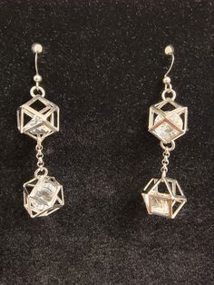 These silver plated geometrically shaped, hollow earrings with faceted glass on the inside are stunning to me. A friend of mine says I make chandeliers and these are the closest I believe I have come so far. They are light since they are mostly just an outline of metal with surgical steel chain running between them. Everything hangs from hypoallergenic silver hooks. Modern Silver Metal Crystal Earrings, Modern Silver Crystal Earrings, Formal Silver Faceted Crystal Earrings, Silver Faceted Dangle Crystal Earrings, Silver Faceted Drop Earrings, Modern Sterling Silver Dangle Crystal Earrings, Modern Sterling Silver Crystal Earrings In Silver, Silver Geometric Pierced Earrings, Silver Faceted Earrings For Party