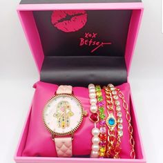 a pink box with several bracelets and watches in it