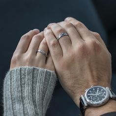 a man and woman holding hands while wearing matching rings on their fingers with the other hand