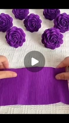 someone is making purple flowers out of fabric