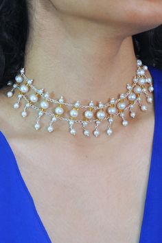 Experience the harmonious blend of natural beauty and timeless elegance with our Pearls and Crystals Symphony Necklace. Hand-crafted from freshwater pearls and crystals in various sizes, this exquisite choker-style necklace is the epitome of sophistication. The luminous natural pearls framed with golden Swarovski crystals, create a mesmerizing effect that will add a touch of glamour to any outfit, especially an off-shoulder dress or blouse. Ivory Sea Cultured Pearls Golden Swarovski Crystals Met White Pearl Drop Choker Jewelry, Elegant Pearl Drop Choker With Round Beads, Pearl Drop Beaded Pearl Choker Necklace, Pearl Drop Beaded Choker Necklace, White Bridal Pearl Choker Necklace, Pearl White Akoya Pearl Bridal Necklace, Pearl White Pearl Pendant Choker, Silver Pearl Drop Choker, Silver Pearl Choker With Pearl Charm