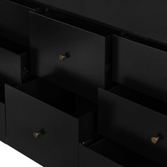 the drawers are black and have gold handles on each one side, which is open to reveal several compartments