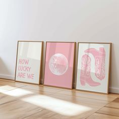 three framed posters on the wall in an empty room with hard wood flooring and white walls