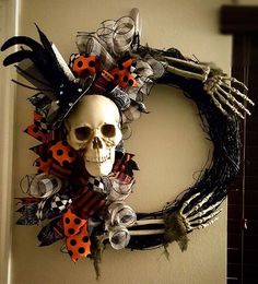 a wreath decorated with skulls and ladybugs is hanging on the wall next to a door