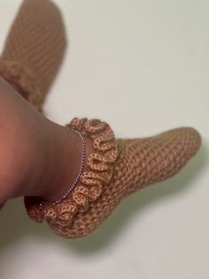 a woman's feet wearing brown crocheted socks